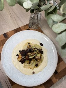 Gebackener Kohlrabi auf Cashewcreme mit schwarzen Bohnen und Pilzen getoppt