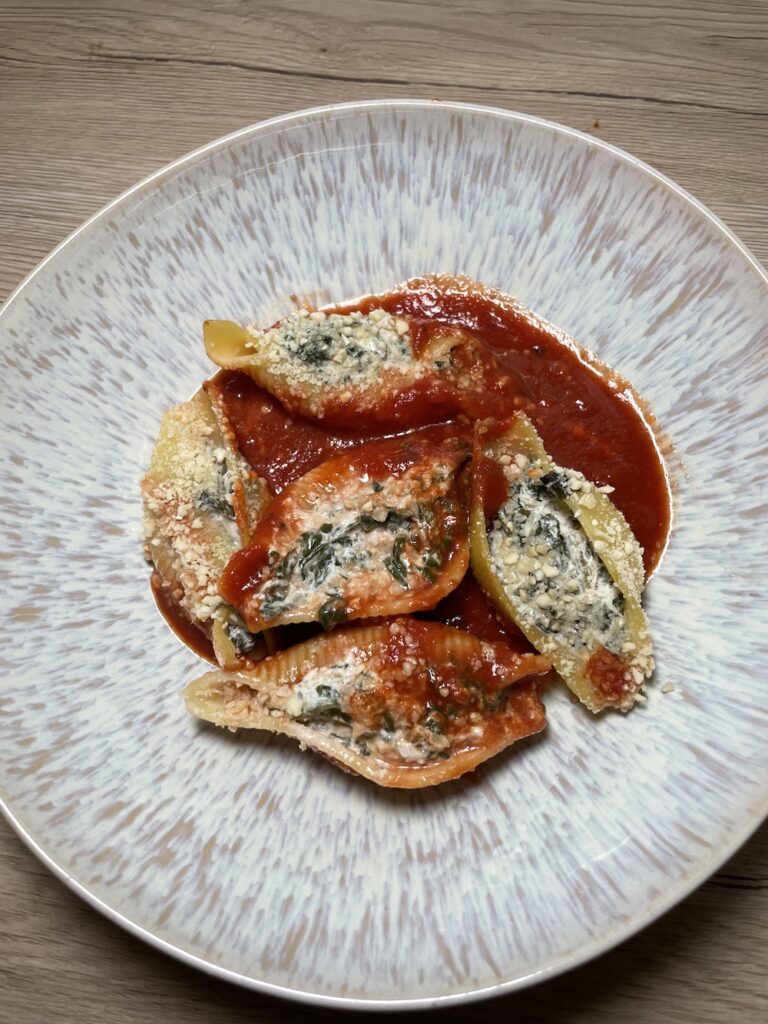 Muschelnudeln mit einer veganen Spinatfüllung auf Tomatensauce im Ofen