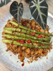 Grüner Spargel auf weißen Riesenbohnen und Tofu