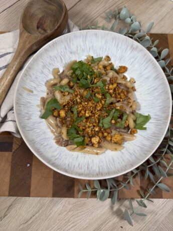 Karamellisierte Zwiebeln mit Nudeln getoppt mit knusprigem Tofu und Petersilie