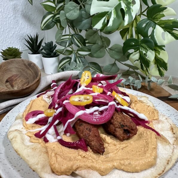 Vegane Hackfleischspieße auf Flatbread mit Hummus und Pickles